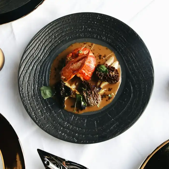 Une assiette de saison servie sur un plat en céramique noire